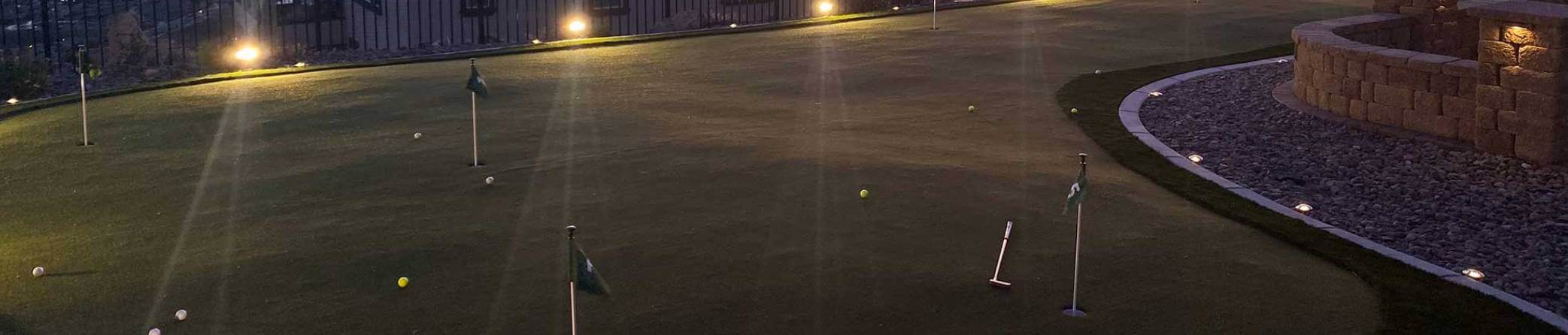 Night time shot of a backyard putting green from Nevada Artificial Turf