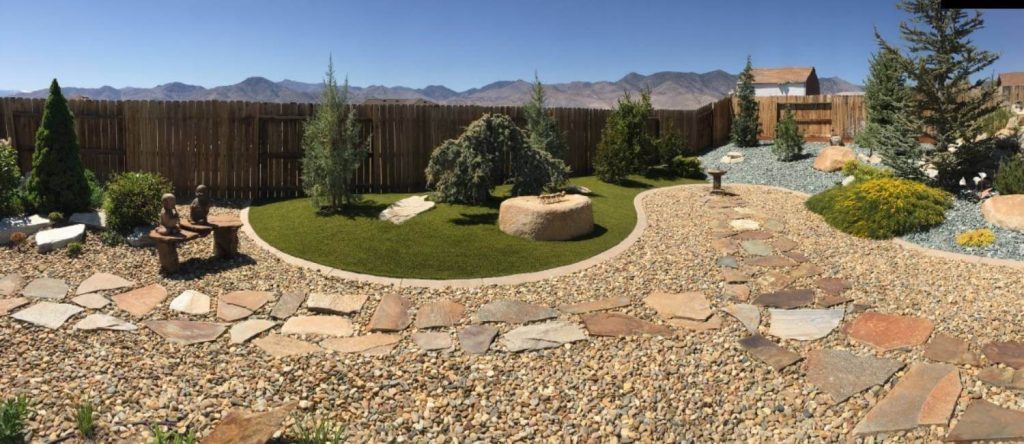 Residential artificial grass backyard with gravel